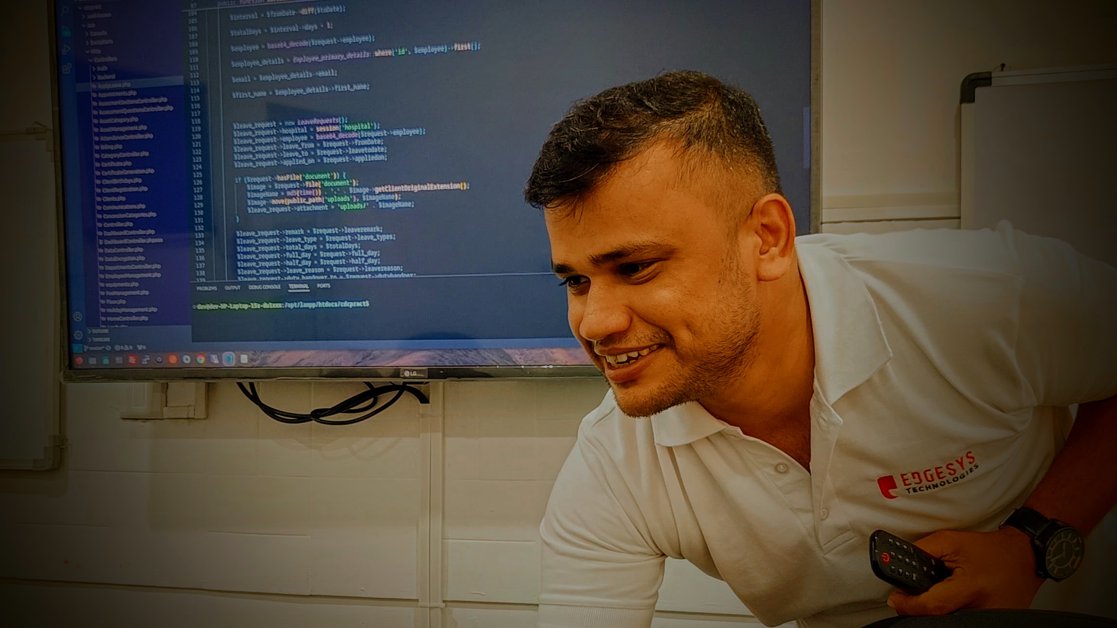Abin Antony, freelance Laravel and PHP developer in Kochi, Kerala, reviewing code on a large monitor